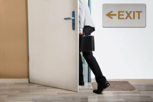 man walking through door, exit sign